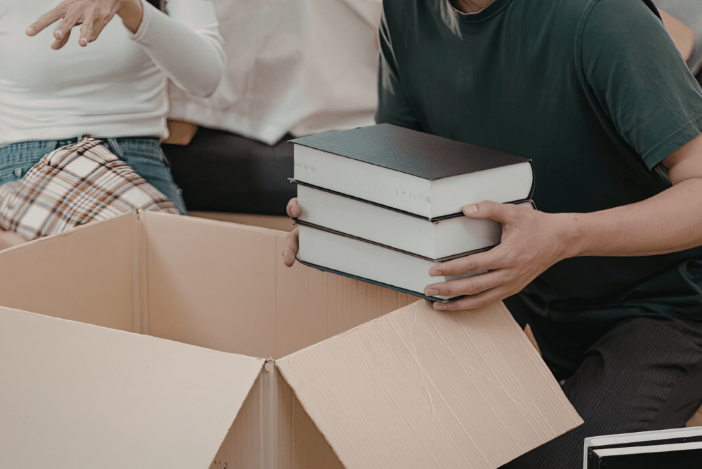 people putting books in a box